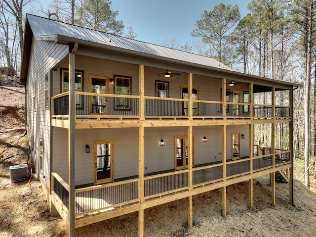 rear view of property featuring a deck, central AC, a ceiling fan, and metal roof