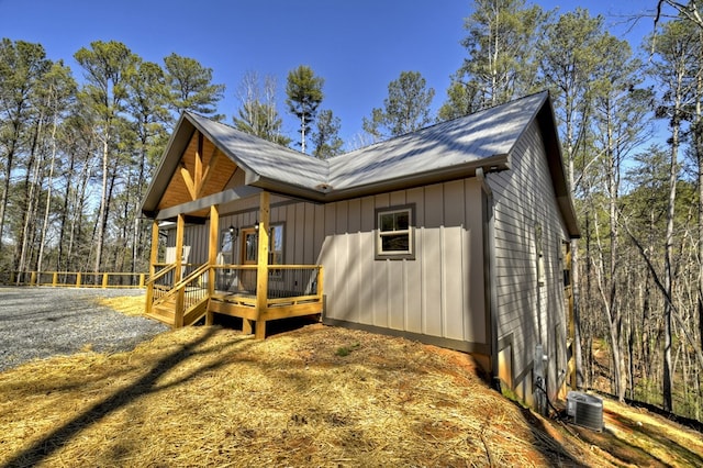 view of side of property with a wooden deck, board and batten siding, and central AC unit