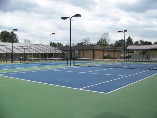 view of tennis court featuring fence