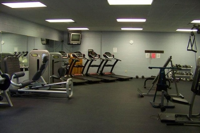 exercise room featuring concrete block wall