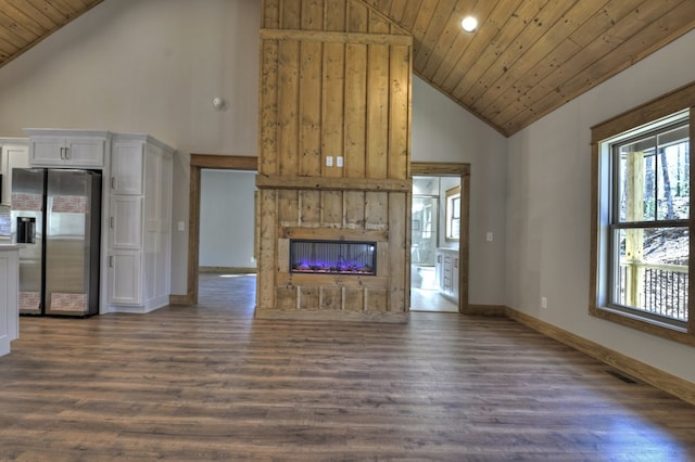 unfurnished living room featuring a glass covered fireplace, wooden ceiling, dark wood-style floors, and baseboards