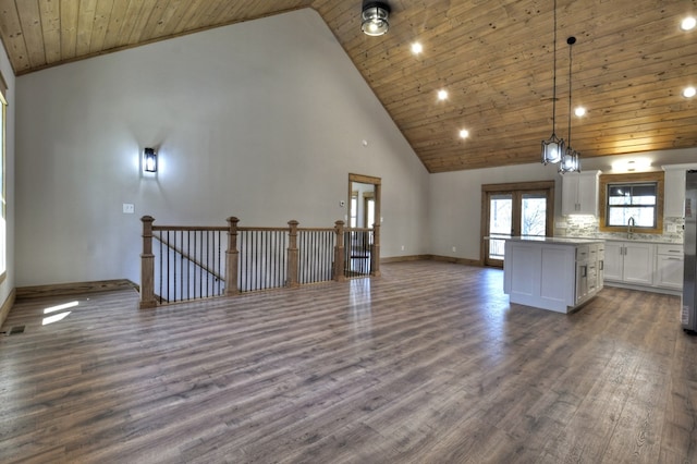 kitchen featuring a sink, dark wood finished floors, a center island, wooden ceiling, and white cabinets