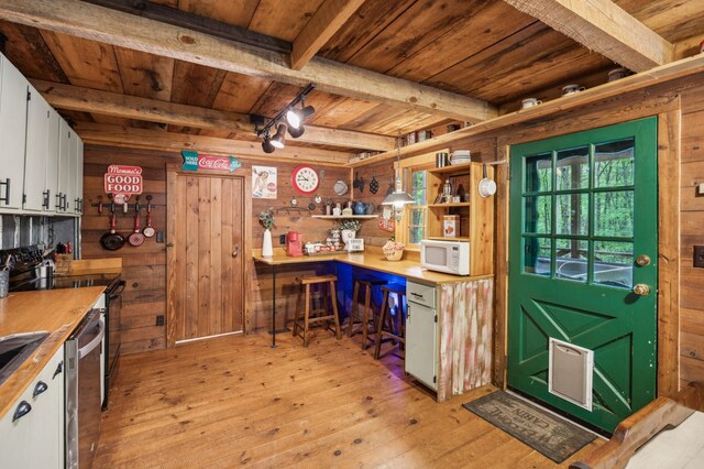 85 Clear Lake Ct, Ellijay, GA 30540 - kitchen featuring wooden ceiling with exposed beams, wooden walls, light wood finished floors, white microwave, and open shelves
