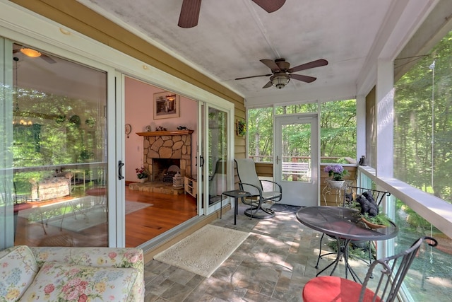 sunroom featuring a stone fireplace