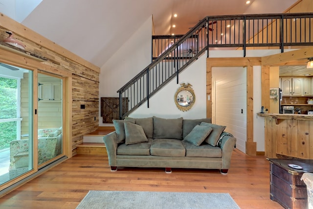 living room with light wood-type flooring and high vaulted ceiling