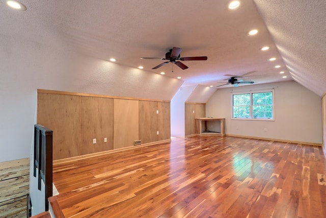 bonus room featuring ceiling fan, a textured ceiling, and hardwood / wood-style flooring