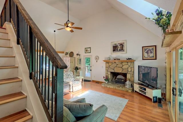 living room featuring high vaulted ceiling, a healthy amount of sunlight, and hardwood / wood-style flooring