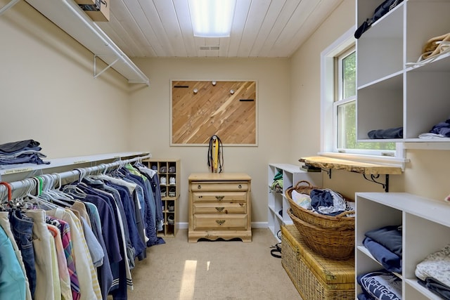 walk in closet featuring light colored carpet