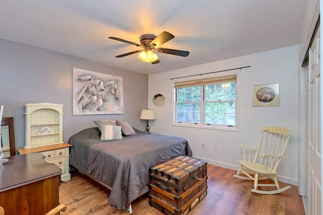 bedroom with hardwood / wood-style floors, ceiling fan, and a closet