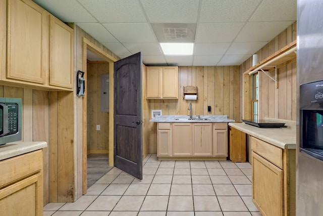 kitchen featuring a paneled ceiling, wood walls, and sink