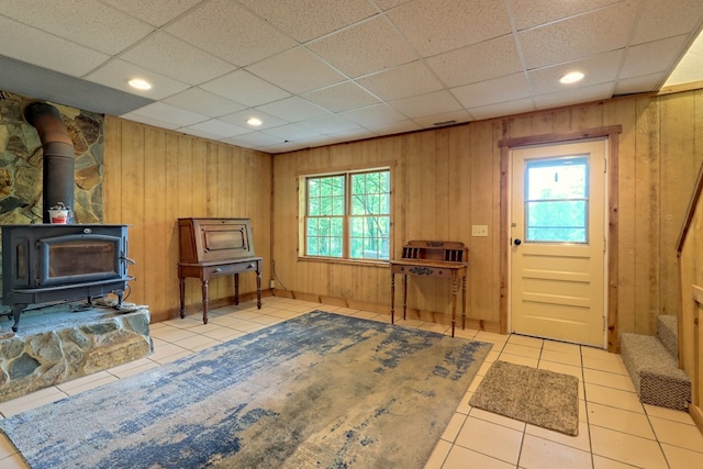 interior space featuring a wood stove, wooden walls, and a healthy amount of sunlight