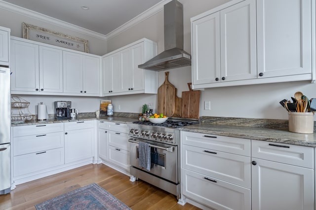 kitchen with white cabinetry, wall chimney exhaust hood, and appliances with stainless steel finishes