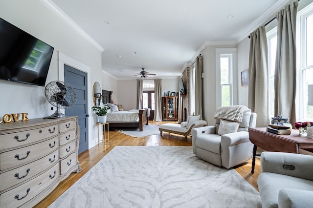 bedroom with ornamental molding, ceiling fan, and light wood-style flooring