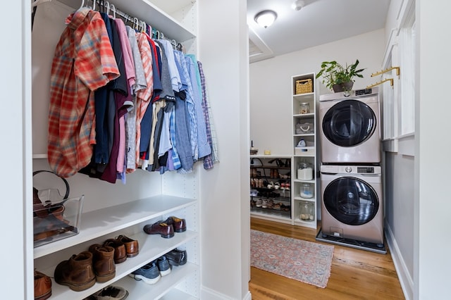 washroom featuring laundry area, stacked washer / dryer, and wood finished floors