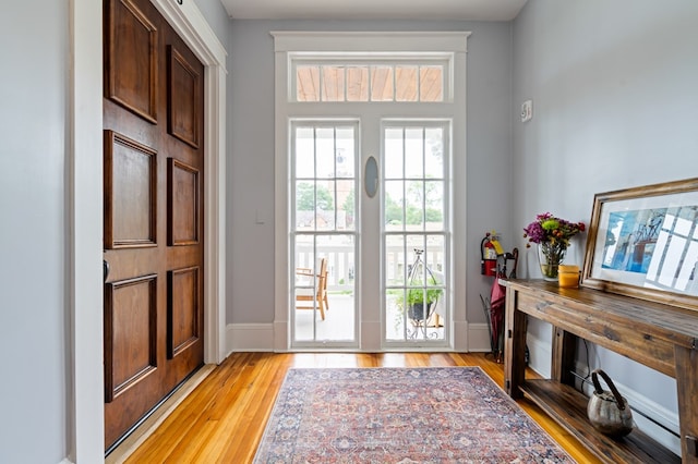 doorway with light wood-style flooring and baseboards