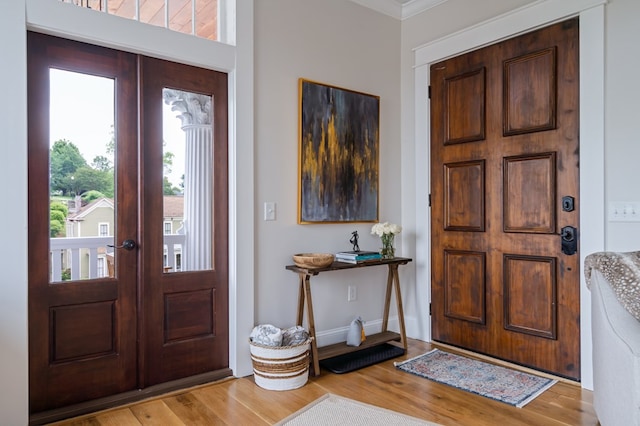 entrance foyer with light wood-style flooring, baseboards, and french doors