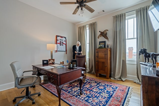 home office featuring visible vents, ceiling fan, light wood-style flooring, and baseboards