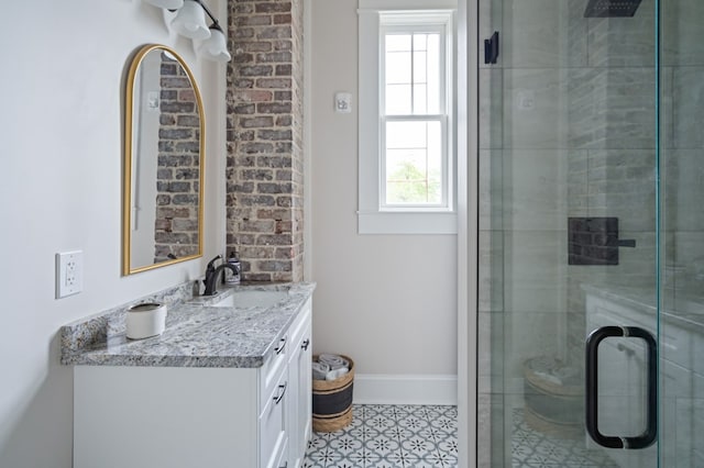 full bathroom with a tile shower, vanity, and baseboards