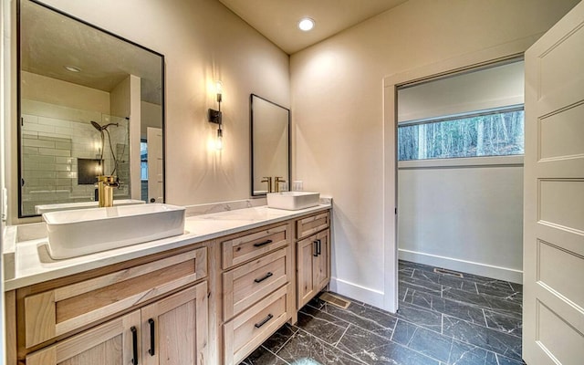 bathroom featuring tiled shower and vanity