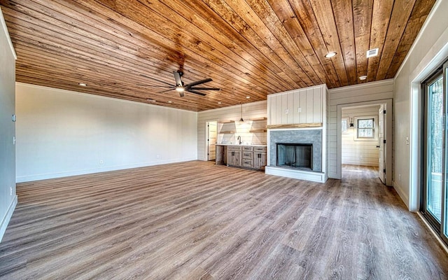 unfurnished living room featuring light hardwood / wood-style floors, ceiling fan, and wooden ceiling