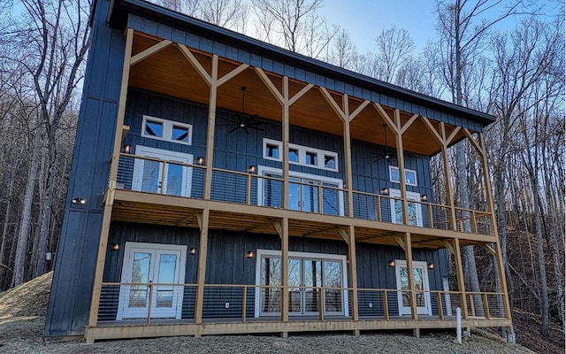 rear view of house with ceiling fan and a balcony