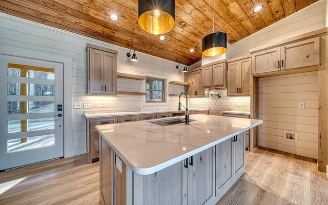 kitchen featuring light wood-type flooring, wood ceiling, a center island with sink, hanging light fixtures, and lofted ceiling