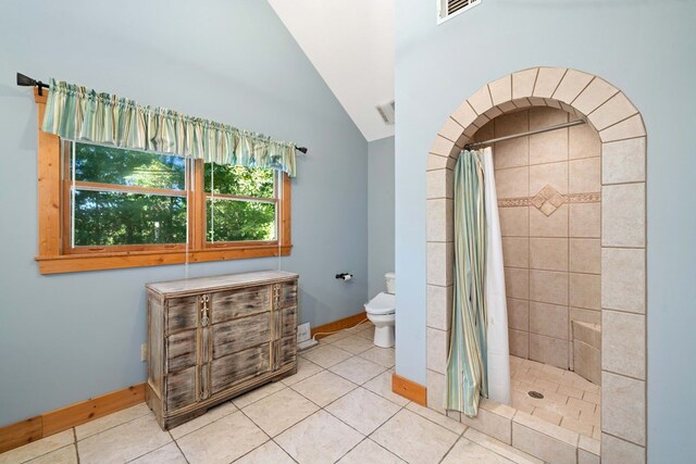 bathroom featuring a shower with shower curtain, tile patterned flooring, and lofted ceiling