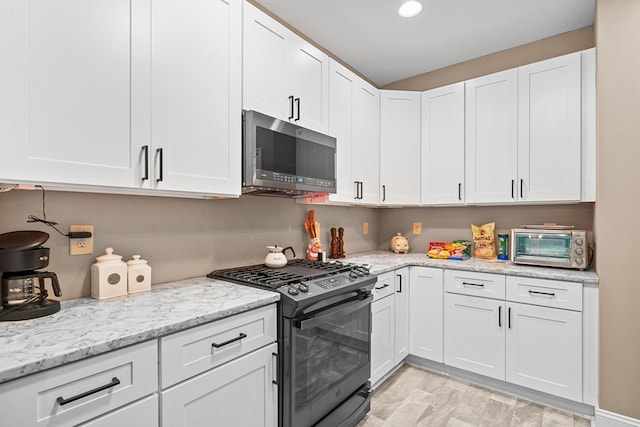 2092 Pleasant Grove Rd, Blairsville, GA 30512 - kitchen featuring stainless steel microwave, black gas range, white cabinets, light stone countertops, and recessed lighting