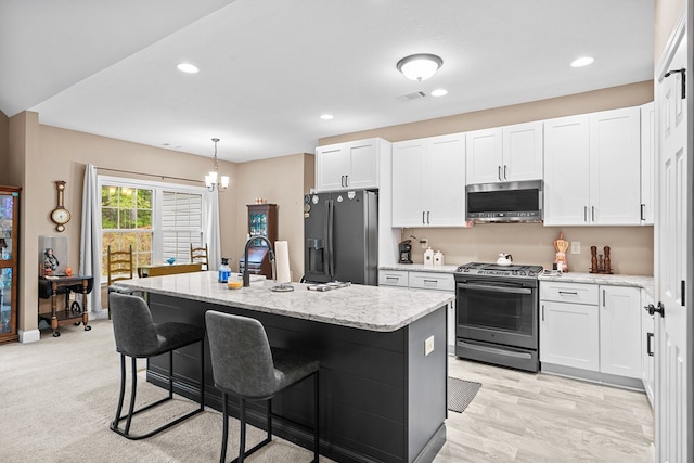 2092 Pleasant Grove Rd, Blairsville, GA 30512 - kitchen featuring stainless steel appliances, white cabinetry, a kitchen island with sink, a sink, and a kitchen bar