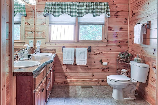 bathroom featuring wooden walls, vanity, and toilet