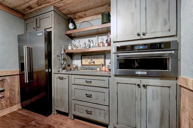 kitchen featuring wooden ceiling, gray cabinets, stainless steel appliances, and hardwood / wood-style flooring