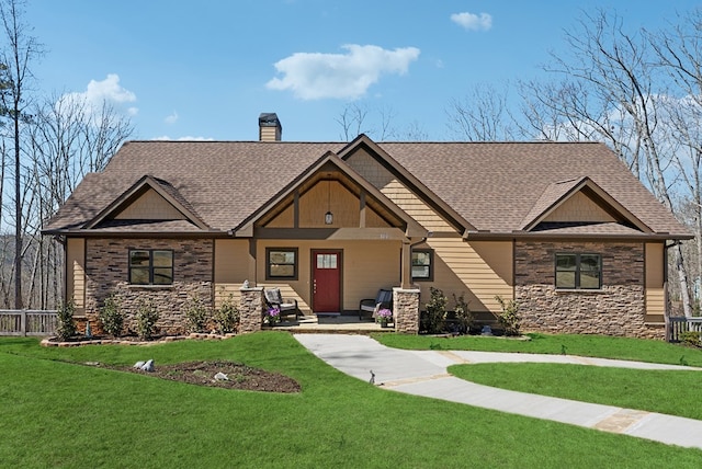 craftsman-style home with stone siding, a shingled roof, a chimney, and a front lawn