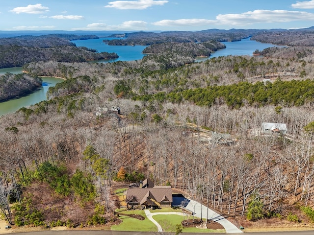 birds eye view of property with a water view and a wooded view