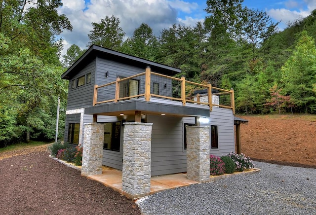 view of front of property featuring stone siding and a wooden deck