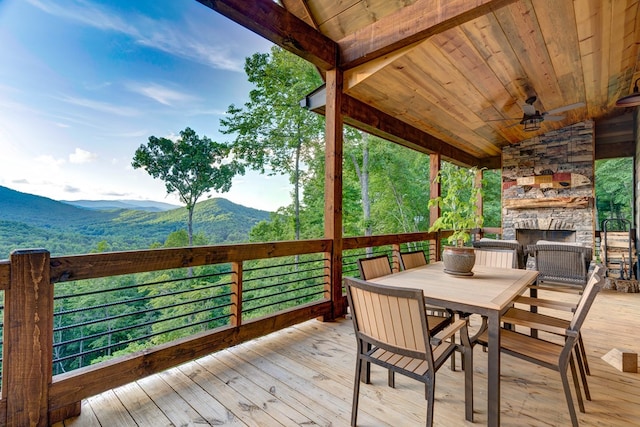 370 High Ridge Rd, Epworth, GA 30513 - deck with an outdoor stone fireplace, a mountain view, a ceiling fan, and outdoor dining area