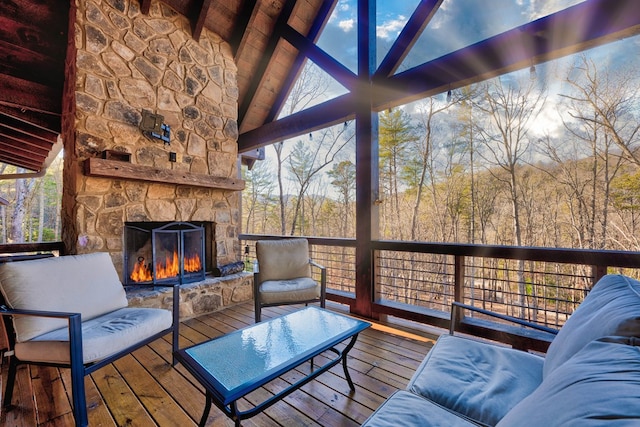 wooden terrace with an outdoor stone fireplace