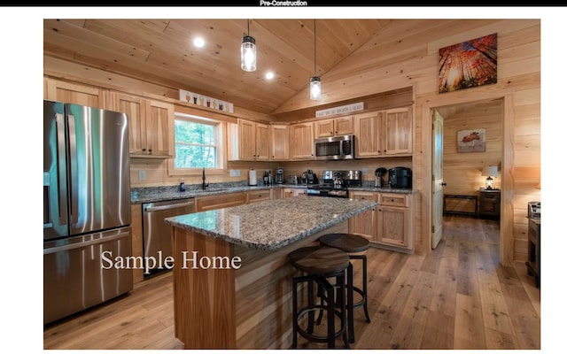 kitchen with a kitchen island, lofted ceiling, hanging light fixtures, stainless steel appliances, and light stone countertops