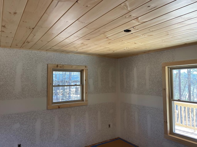 empty room with crown molding and wood ceiling