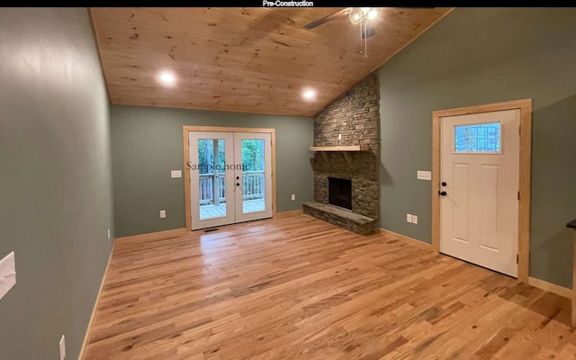 unfurnished living room with french doors, vaulted ceiling, wooden ceiling, a fireplace, and light hardwood / wood-style floors