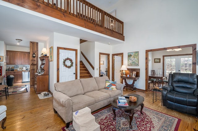 living room with light hardwood / wood-style flooring, french doors, and a high ceiling