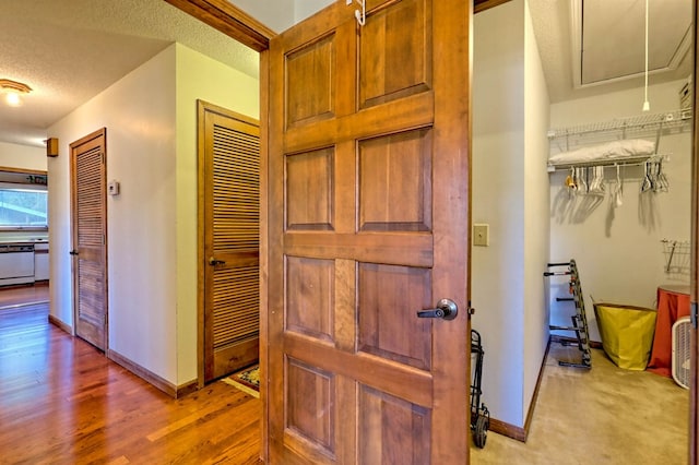 hall featuring a textured ceiling and light hardwood / wood-style floors