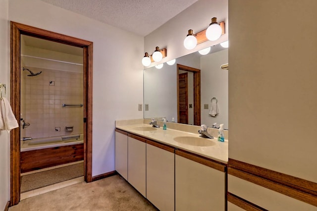 bathroom featuring tiled shower / bath, vanity, and a textured ceiling