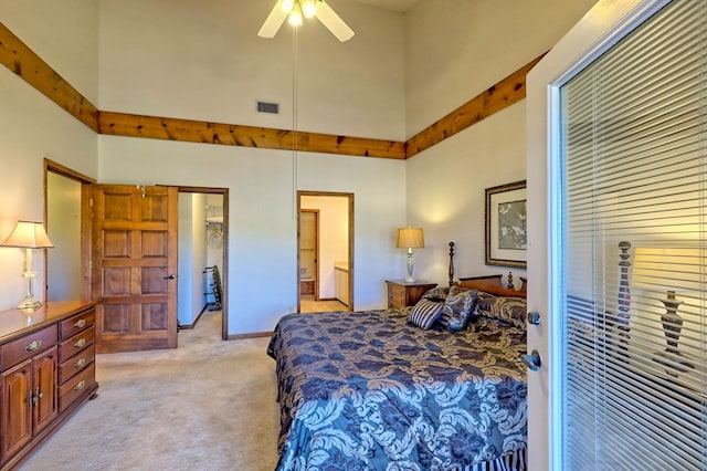 carpeted bedroom with a towering ceiling and ceiling fan