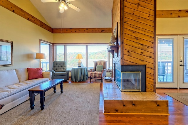 tiled living room featuring ceiling fan and high vaulted ceiling