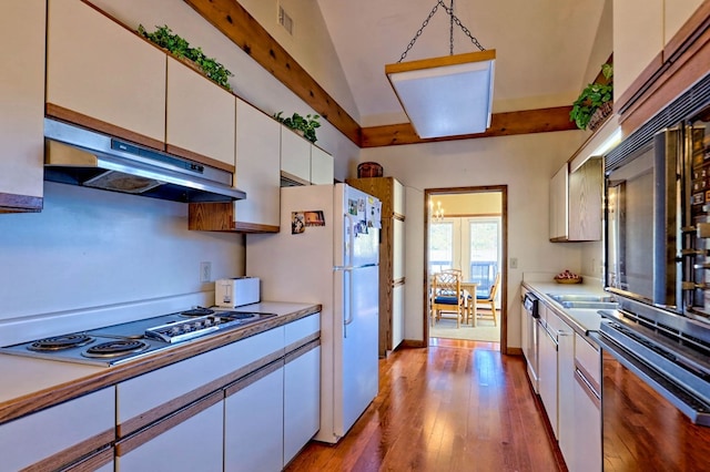 kitchen featuring decorative light fixtures, white cabinetry, white fridge, stainless steel gas cooktop, and light wood-type flooring