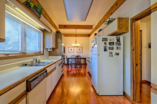 kitchen featuring decorative light fixtures, sink, white cabinets, white appliances, and light wood-type flooring