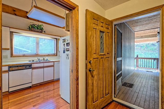 interior space featuring sink, a wealth of natural light, light hardwood / wood-style floors, and a textured ceiling