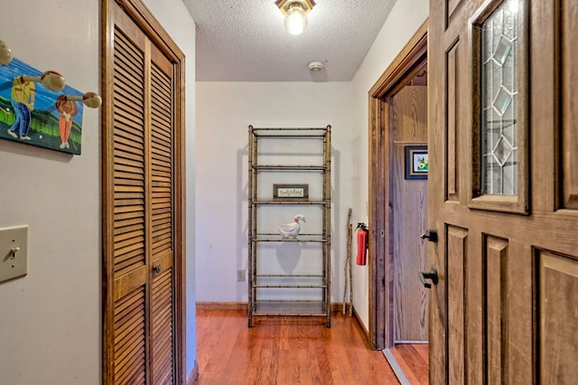 hallway featuring dark wood-type flooring and a textured ceiling