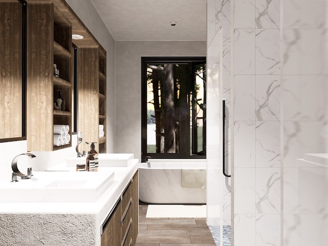 bathroom with a freestanding bath, double vanity, wood finished floors, and a sink