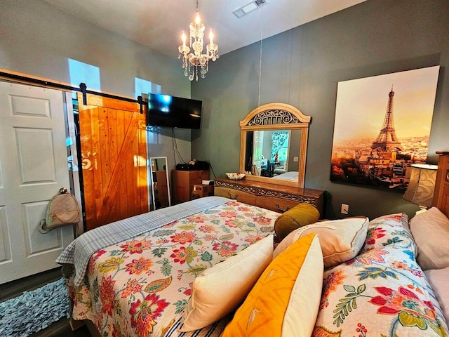 bedroom featuring an inviting chandelier and a barn door